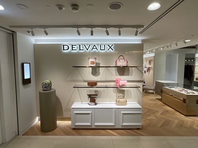 Delvaux — Harrods — Brand signage above bespoke shelving and cabinetry wall